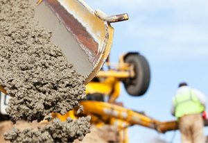 Construction Worker Guiding Cement Mixer Truck Trough